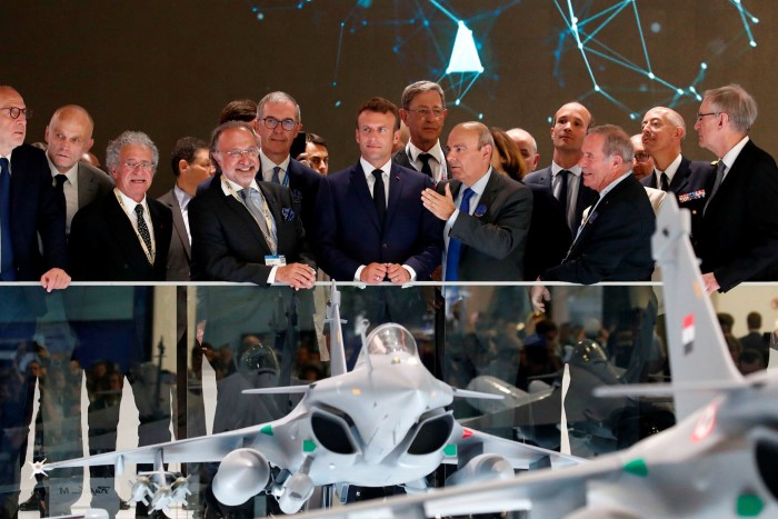French President Emmanuel Macron, centre, listens to Eric Trappier, head of Dassault Aviation, at the Paris air show