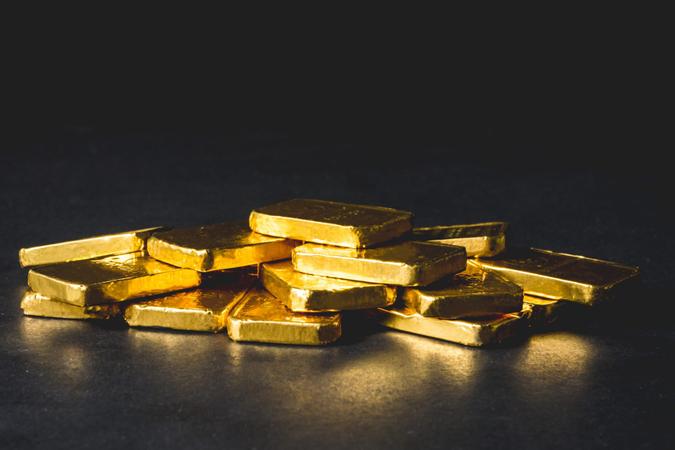 Stack of Pure gold bars on black background.