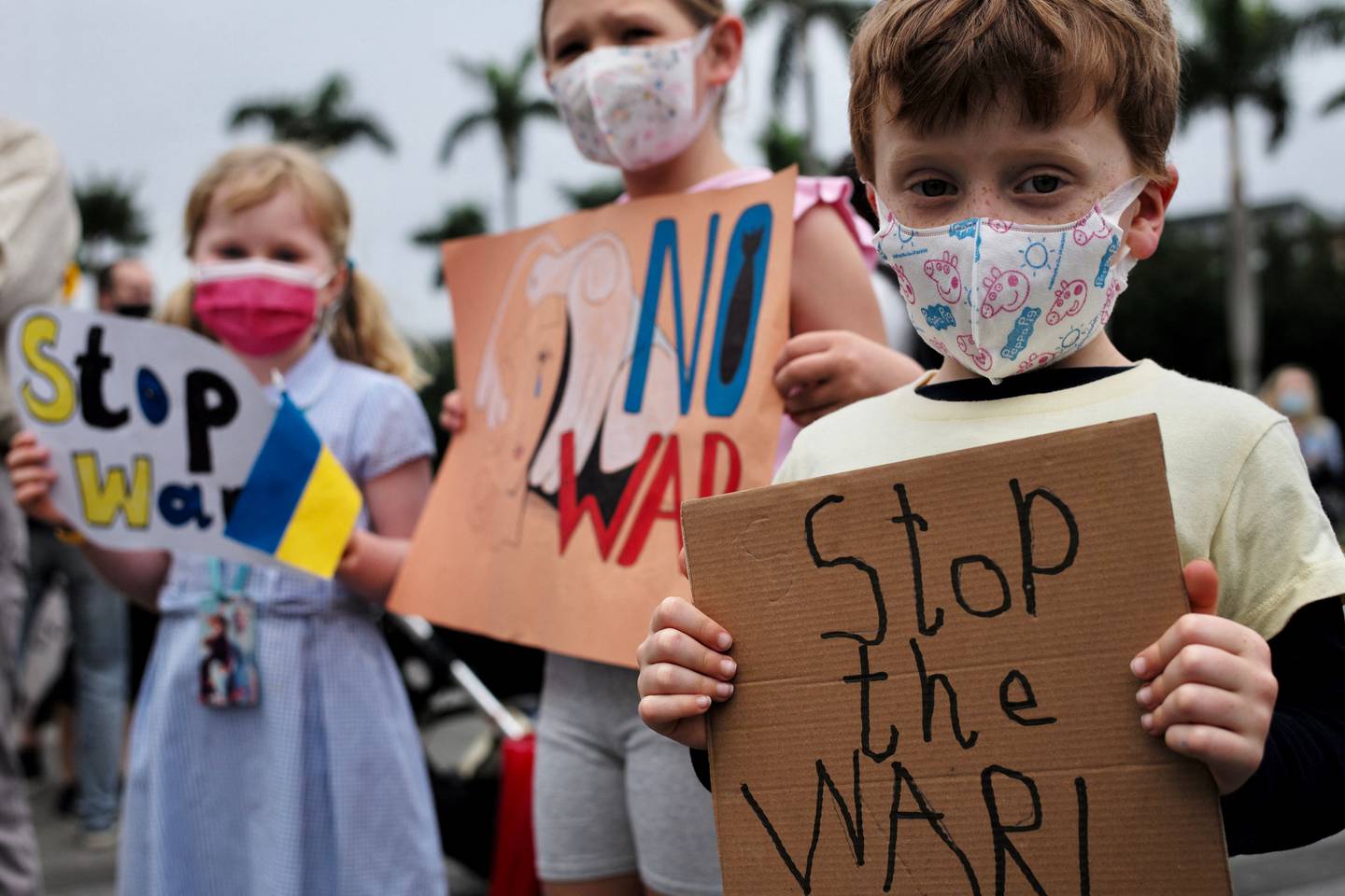 Three Slavic children living in Taiwan display posters during a protest against Russia's military intervention in Ukraine at the Free Square outside the Chiang Kai-shek Memorial Hall in Taipei on March 6, 2022. AFP