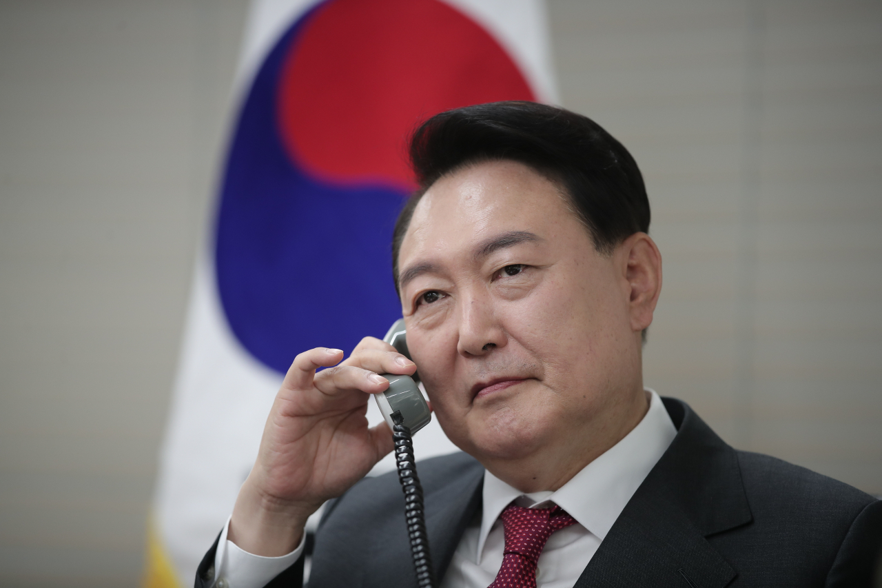 This photo provided by the People Power Party on Friday, shows President-elect Yoon Suk-yeol speaking with Japanese Prime Minister Fumio Kishida over the phone at his party's headquarters in Seoul. (Yonhap)
