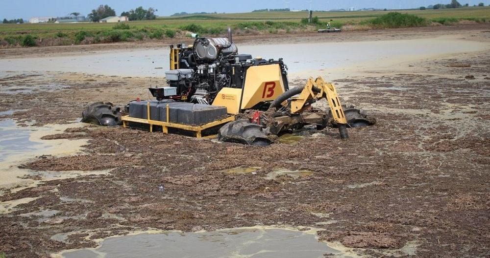 An agitator stirs up the liquid manure in a retention pond.