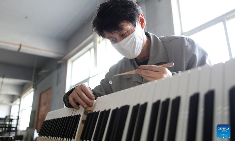 A worker adjusts piano components at Dongbei Piano Musical Instruments Co., Ltd. in Yingkou, northeast China's Liaoning Province, April 25, 2022. Dongbei Piano Musical Instruments Co., Ltd., formerly known as Dongbei Piano Factory in Yingkou, is gradually resuming production with epidemic prevention measures in place.(Photo: Xinhua)