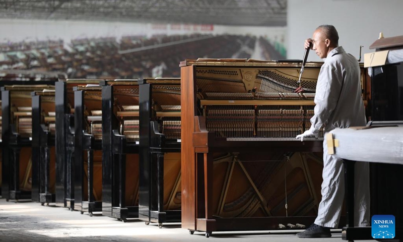 A tuner tunes a piano at Dongbei Piano Musical Instruments Co., Ltd. in Yingkou, northeast China's Liaoning Province, April 25, 2022. Dongbei Piano Musical Instruments Co., Ltd., formerly known as Dongbei Piano Factory in Yingkou, is gradually resuming production with epidemic prevention measures in place.(Photo: Xinhua)
