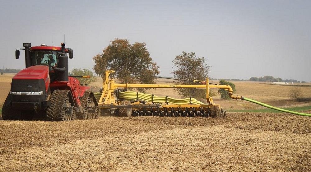 A farmer spreads liquid manure over a farm field.