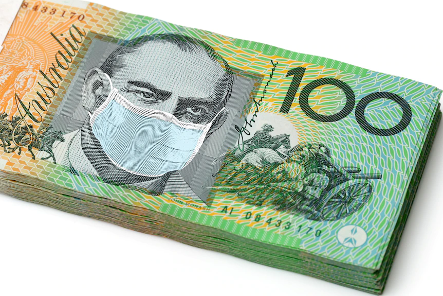 Pile of 100 dollar notes with a face mask placed on top of the historical figure pictured. 