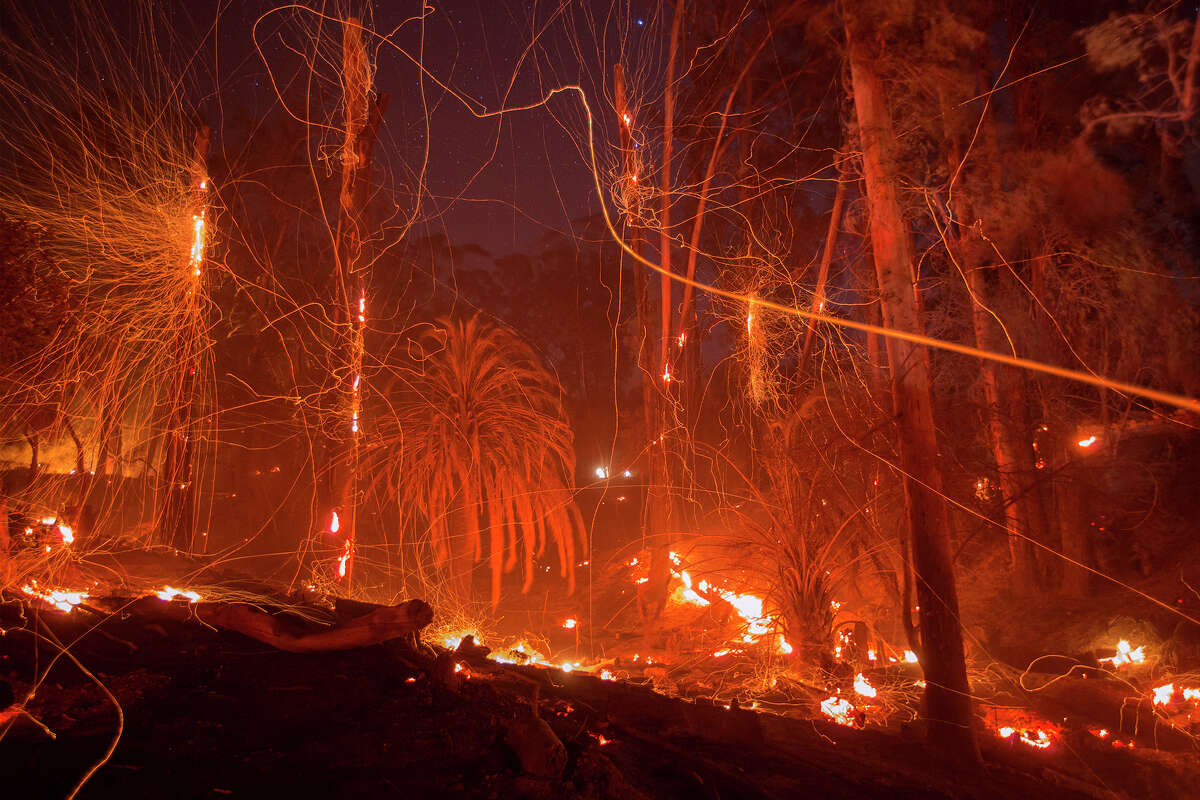 A strong wind blows embers from smoldering trees at the Thomas Fire on Dec. 16, 2017, in Montecito. The fire later ushered in mudslides that winter that killed 23 in the town. Today, homeowners in the ultra-wealthy enclave have a difficult time insuring their properties.