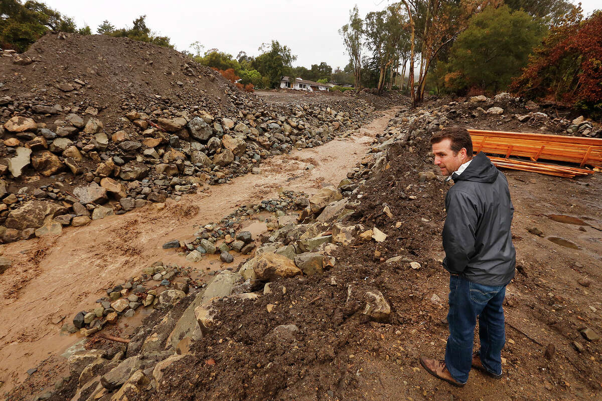 Montecito resident Keith Hamm checks on San Ysidro Creek where it crosses East Valley Road in Montecito on Wednesday, March 21, 2018, as rain continues to fall in the area.