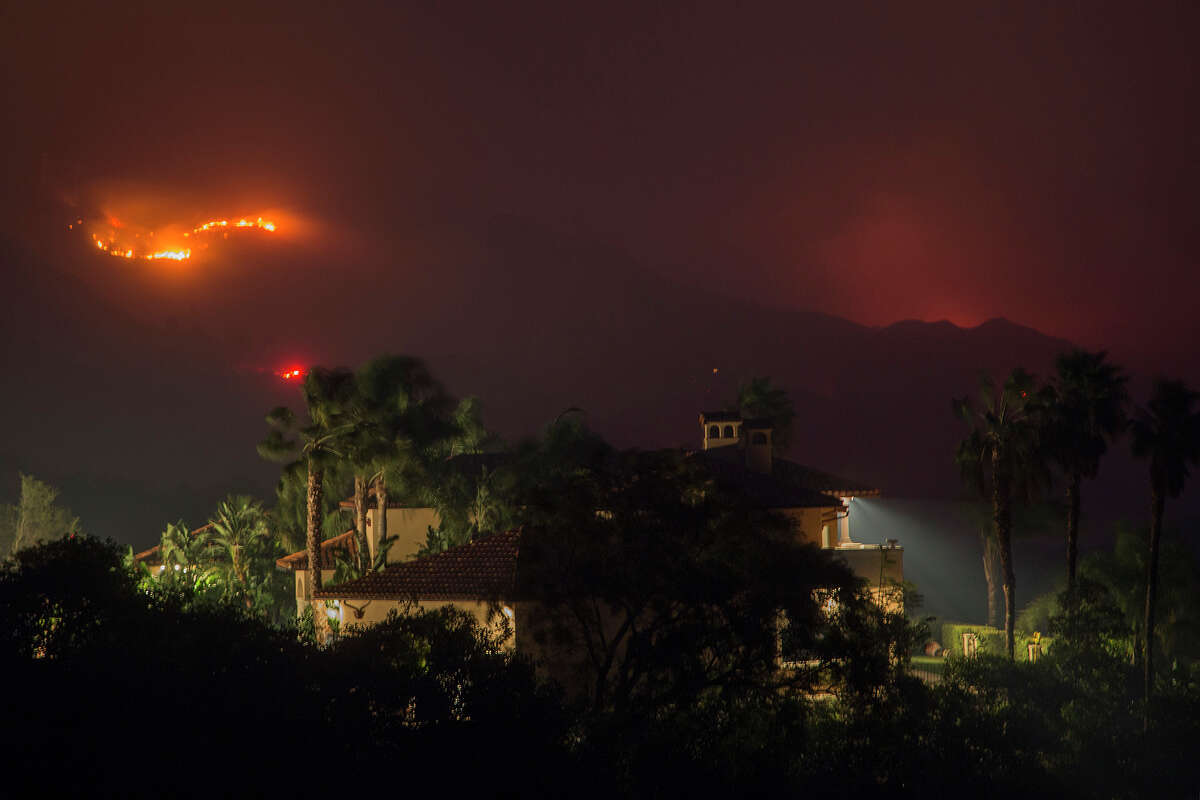 Flames threaten homes at the Thomas Fire on December 16, 2017 in Montecito. The fire, which took more than six months to fully extinguish, led to a tragic mudslide in Montecito that caused extensive damage and took 23 lives. Now Montecito residents face challenges trying to insure their mega-million-dollar properties.