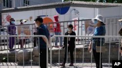 Residents line up for mass COVID test on May 16, 2022, in Beijing.