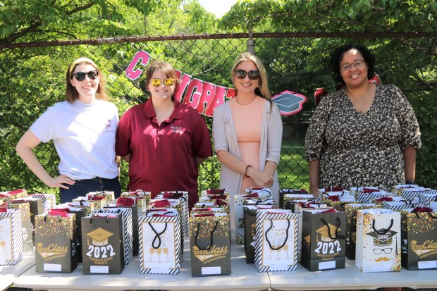(L. to r.) Goodrich Academy English teacher Lindsay Page, school nurse Rachel Bordieri, Career Liaison Sarah Henry, and Academic Interventionist Chante Coley handed out gift bags to the members of the Class of 2022 at the Senior Celebration at the Fitchburg school on May 25. (DANIELLE RAY/SENTINEL & ENTERPRISE)