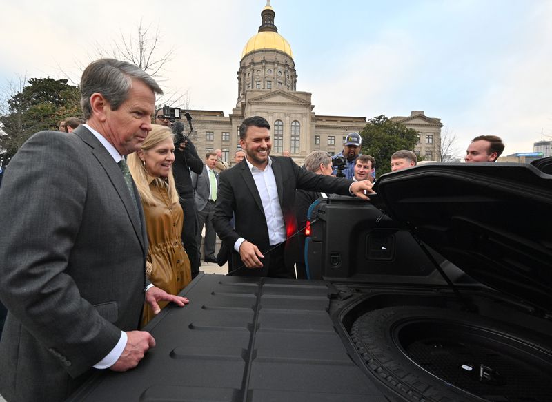 December 16, 2021 Atlanta - Jimmy Knauf EVP of Facilities at Rivian, smiles as he shows Rivian R1T electric truck to Georgia Governor Brian Kemp (left) and First Lady Marty Kemp (second from left) during a press conference at Liberty Plaza across from the Georgia State Capitol in Atlanta on Thursday, December 16, 2021. (Hyosub Shin / Hyosub.Shin@ajc.com)