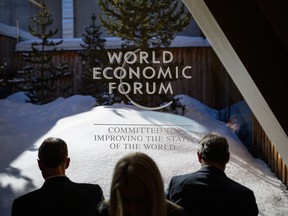 Participants check their messages on electronic devices during the World Economic Forum (WEF) annual meeting in Davos on Jan. 23, 2020.