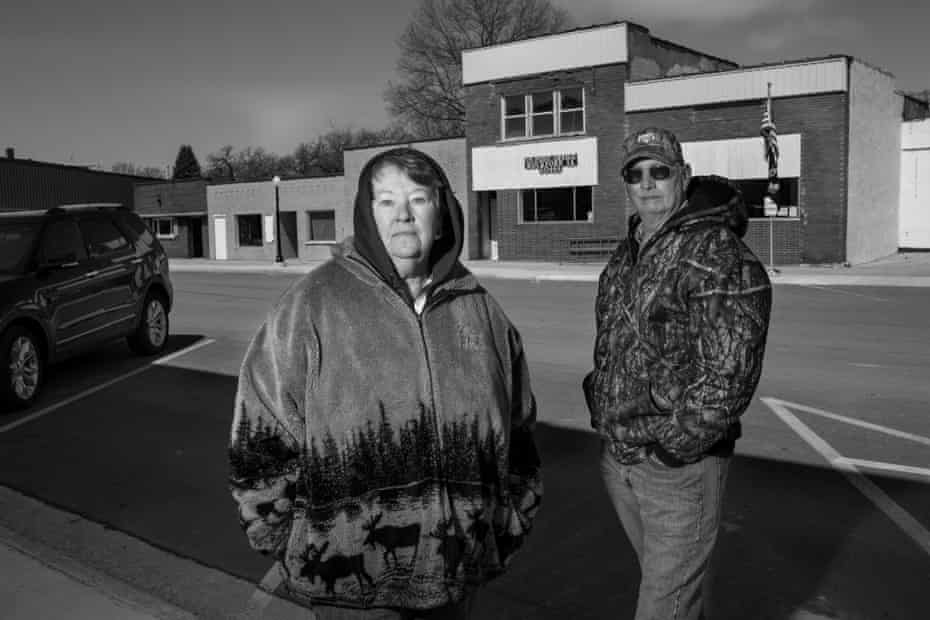 A man and woman stand in the parking lot of a post office in this black-and-white image.