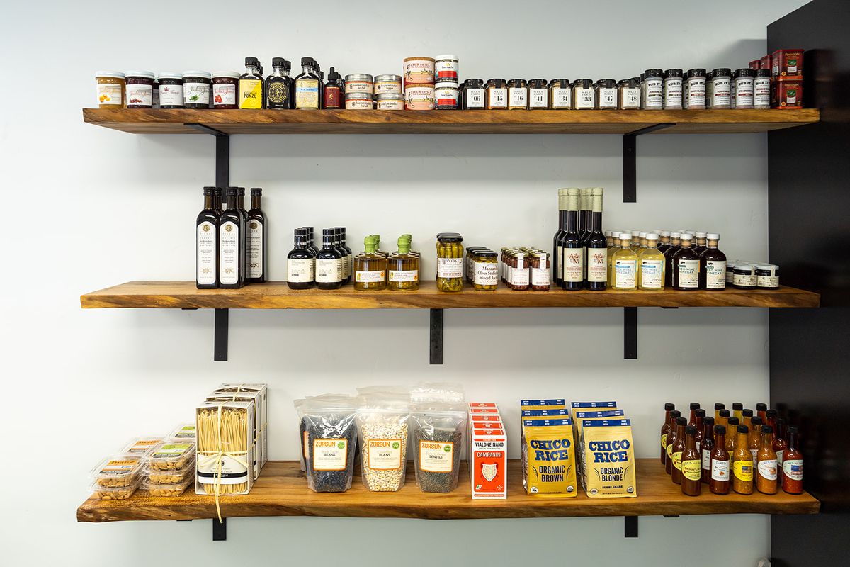 Shelves of gourmet grocery items like jams, sauces, and beans.