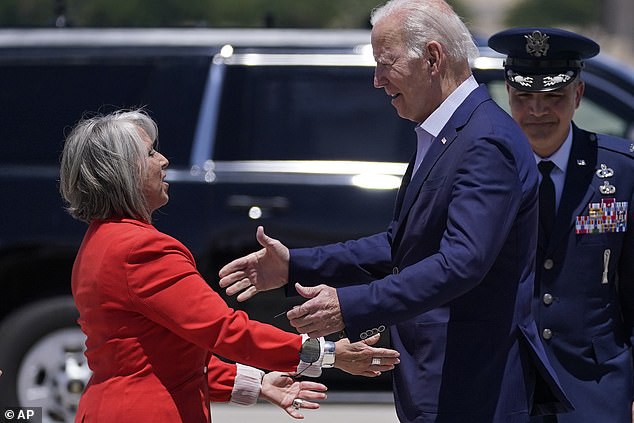 President Joe Biden (right) hugged New Mexico's Democratic Gov. Michelle Lujan Grisham (left) upon arrival at Kirtland Air Force Base in Albuquerque, New Mexico