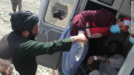 Afghan Red Crescent Society volunteers help people affected by the eartquake in Giyan district.
