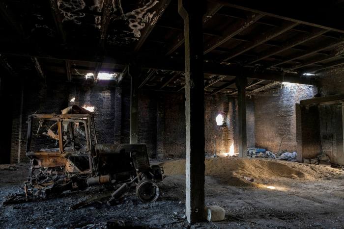 A tractor damaged by a Russian attack lies inside a warehouse at a grain farm in Cherkaska Lozova, near Kharkiv, eastern Ukraine in May
