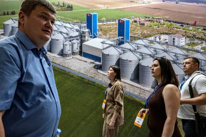 Visitors walk in front of the banner of Turkish company Mysilo Grain Storage Systems during Cereals - Mixed Feed - Veterinary 2022 fair in Moscow last week
