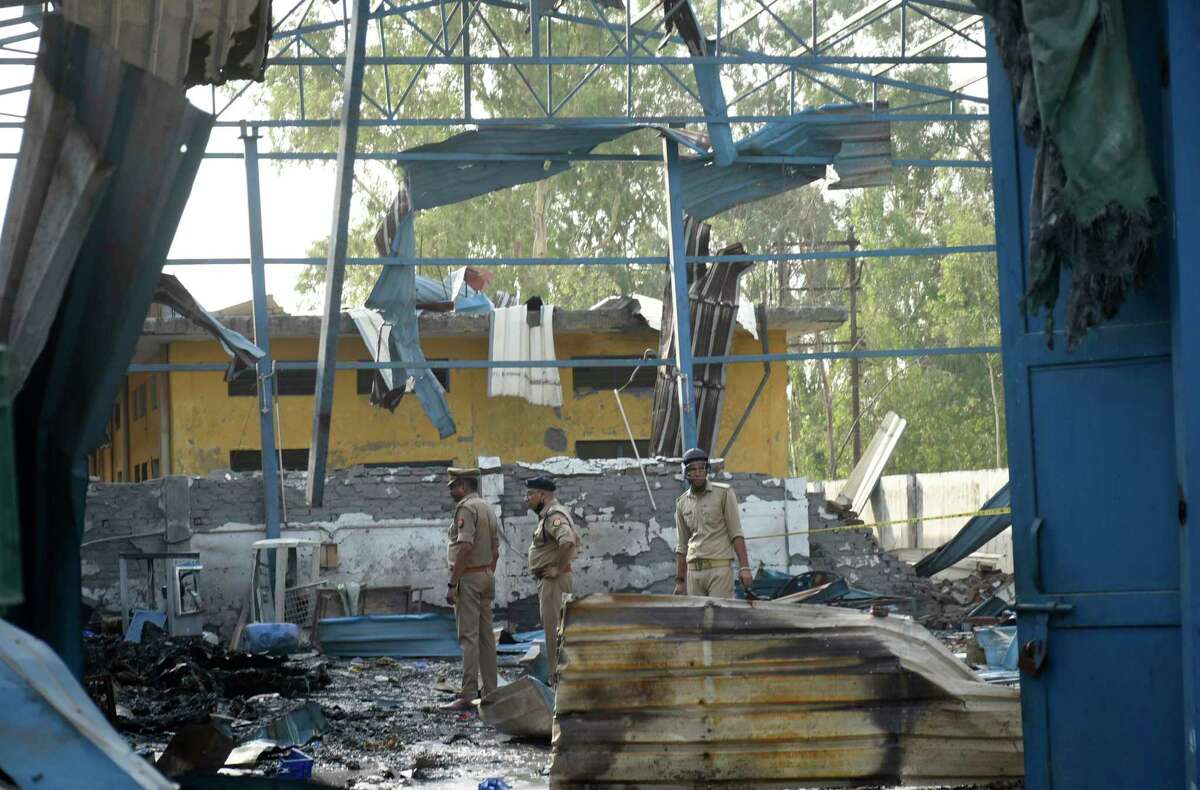 Policemen inspect the site of a fire in Hapur, India, Saturday, June 4, 2022. At least eight workers were killed and more than a dozen others injured after fire erupted in a chemical factory in northern India, police said Saturday.