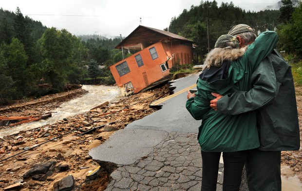 Residents embrace near a washed-out home ...