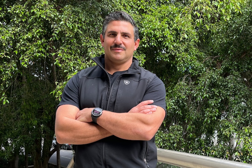 man with folded arms standing near steps 