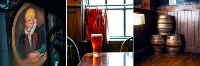 A pub sign, glass of beer and barrels in a London pub