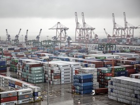 Shipping containers stacked at the Guangzhou Nansha Container Port are seen from CMA CGM SA's Benjamin Franklin container ship docked at the terminal in Guangzhou, China.