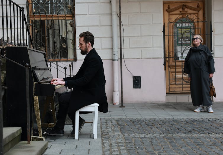 A man plays a piano in the street