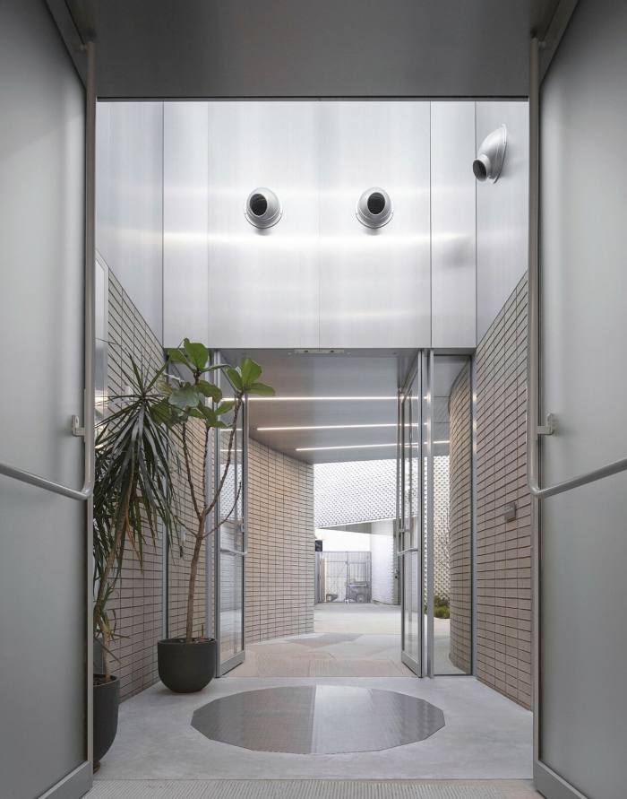 A hallway atrium has a highly polished floor reflecting the sky