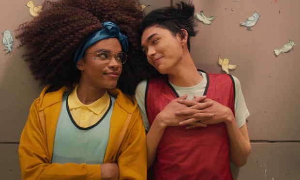 Heartstopper trans actor Yasmin Finney as trans character Elle Argent lying on the floor next to William Gao as Tao with paper butterflies around them