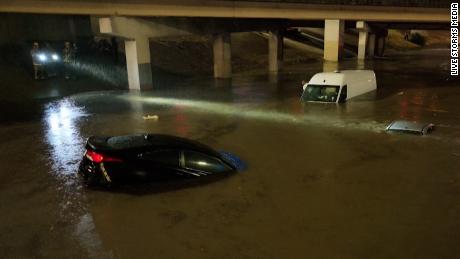 Motorists escape flooded vehicles early Monday in downtown Dallas.