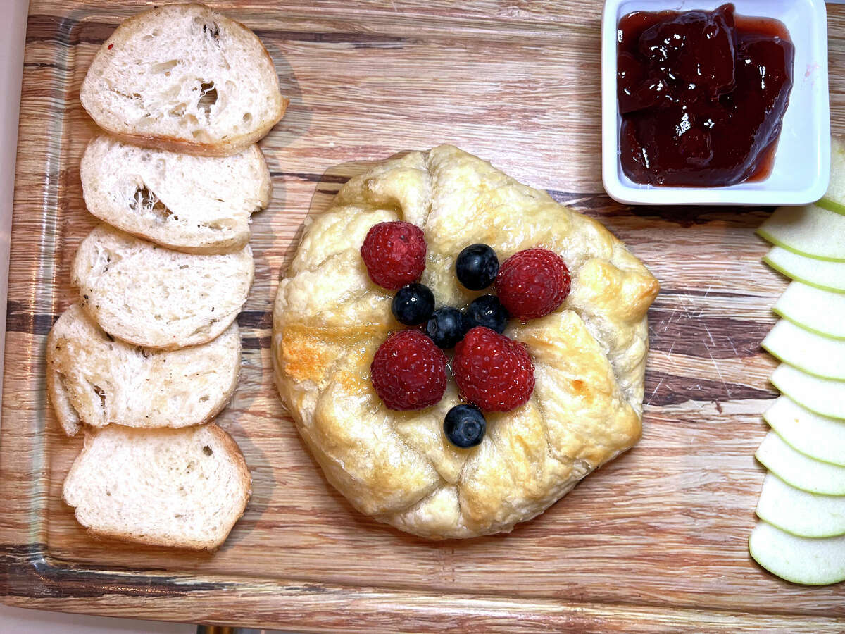 Baked brie in puff pastry is served with berries, strawberry jam and apple slices at Sugar Factory American Brasserie at The Shops at Rivercenter on the San Antonio River Walk.
