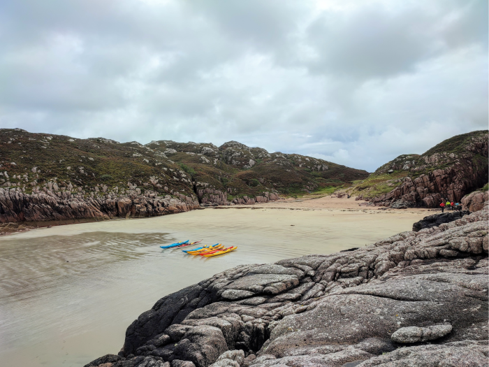 A Wilderness Scotland kayaking group take a break in a remote bay on the Isle of Mull