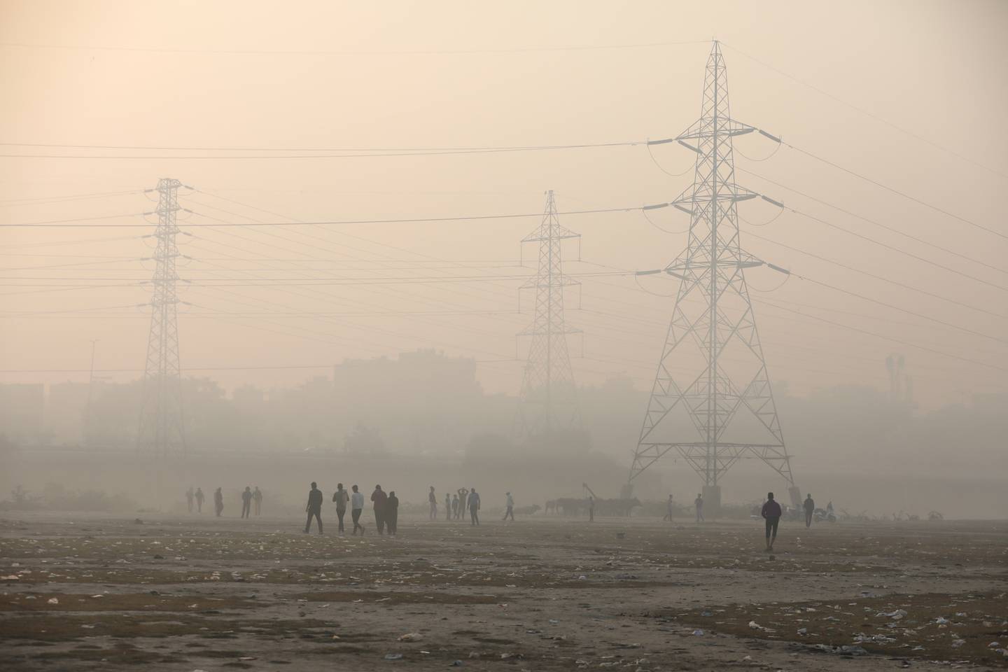 People are seen on the floodplains of the Yamuna river on a smoggy morning in New Delhi, India. Reuters