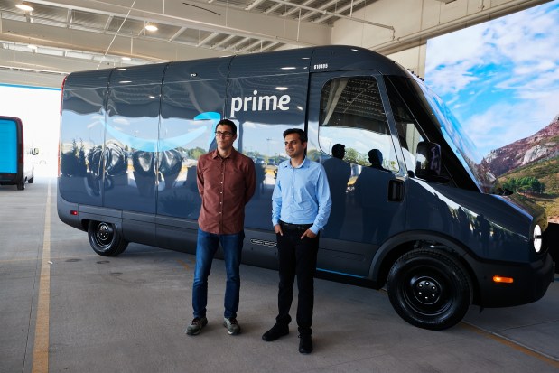 CHICAGO, IL - JULY 21: Founder and CEO of Rivian RJ Scaringe and Amazon Vice President of Transportation Udit Madan, pose with an Electric Delivery Vehicle (EDV), during a launch event at an Amazon facility on July 21, 2022 in Chicago, Illinois. This unveiling is major milestone towards Amazons goal of having 100,000 Rivian EDVs on the road by 2030, and Amazon has made a Climate Pledge commitment to reach net-zero carbon by 2040 and has also pledged to guarantee 50% of all shipments reach net zero carbon by 2030. (Photo by Mustafa Hussain/Getty Images)