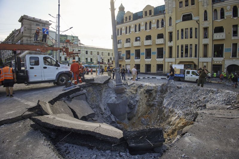 Communal workers operate at a site of a rocket hit in downtown Kharkiv, Ukraine, on Saturday. Photo by Sergey Kozlov/EPA-EFE
