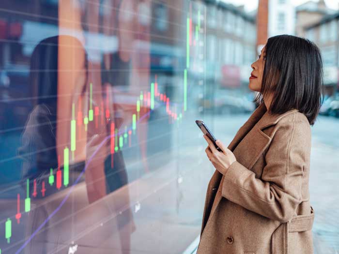 A woman looks at a colourful graph displayed on a large screen