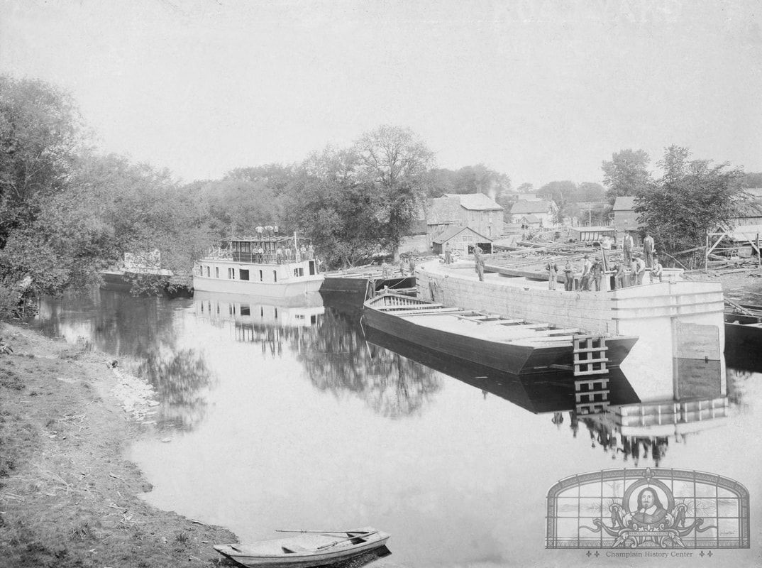 Champlain’s biggest boat yard is shown with a houseboat and canal boat under construction. A barge is moored next to the canal boat. (Photo: champlainhistory.org)