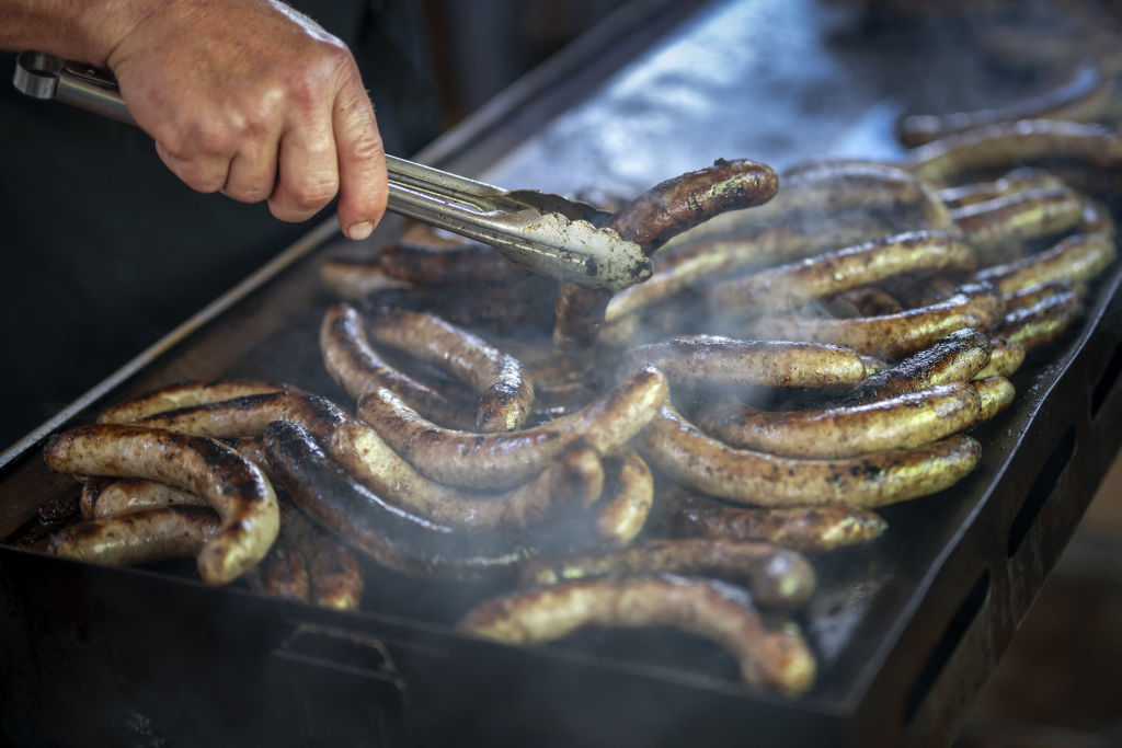 A man cooks sausages during an event marking the 125th anniversary of the Swiss Farmers' Union in the Swiss capital Bern, on Sept. 19, 2022. (Fabrice Coffrini—AFP/Getty Images)
