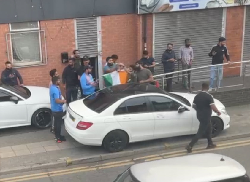 Tensions rise as Hindu men are pictured with a flag on the city's Green Lane as unrest continues