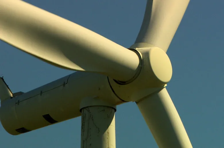 A close-up shot of the blades of a wind turbine.