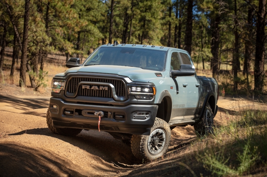 Ram 2500 Power Wagon pickup truck parked on an off-roading trail, trees visible in the background.