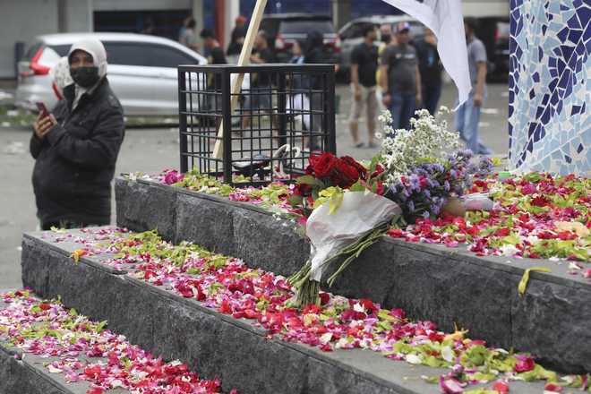 Flowers&#x20;are&#x20;laid&#x20;by&#x20;supporters&#x20;of&#x20;local&#x20;soccer&#x20;club&#x20;Arema&#x20;FC,&#x20;outside&#x20;Kanjuruhan&#x20;Stadium&#x20;where&#x20;riots&#x20;broke&#x20;out&#x20;on&#x20;Saturday&#x20;night&#x20;in&#x20;Malang,&#x20;East&#x20;Java,&#x20;Indonesia,&#x20;Sunday,&#x20;Oct.&#x20;2,&#x20;2022.&#x20;Panic&#x20;at&#x20;the&#x20;soccer&#x20;match&#x20;between&#x20;Arema&#x20;FC&#x20;and&#x20;Persebaya&#x20;of&#x20;Surabaya&#x20;city&#x20;left&#x20;over&#x20;150&#x20;people&#x20;dead,&#x20;most&#x20;of&#x20;whom&#x20;were&#x20;trampled&#x20;to&#x20;death&#x20;after&#x20;police&#x20;fired&#x20;tear&#x20;gas&#x20;to&#x20;dispel&#x20;the&#x20;riots.&#x20;&#x28;AP&#x20;Photo&#x2F;Trisnadi&#x29;