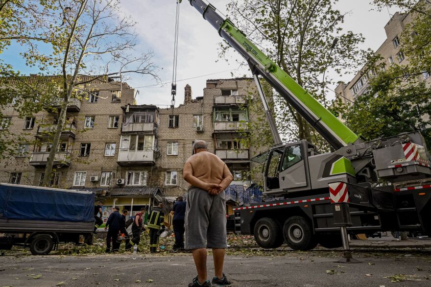 A man looks at a damaged residential building after shelling in Mykolaiv on Oct. 1. One woman died in the attack.