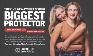Mother embracing daughter with arms in the shape of a seatbelt