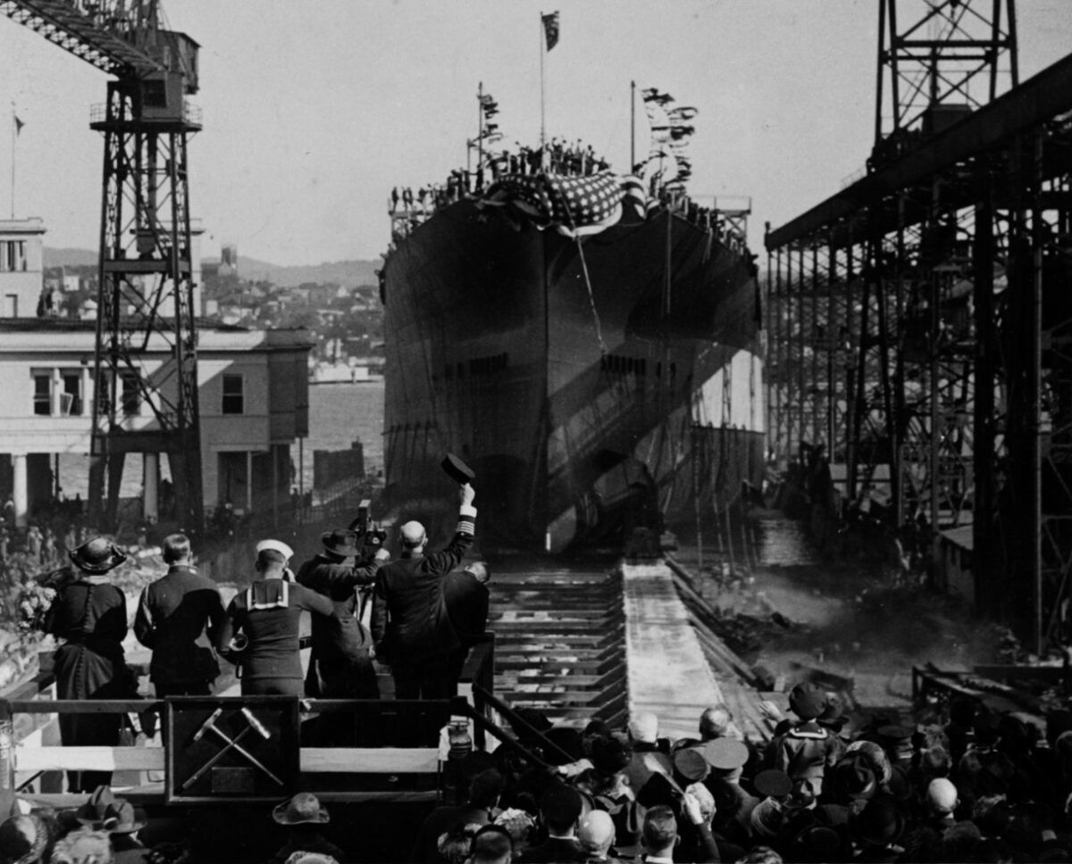 SS California (BB-44) sliding down the building ways during her launching, at the Mare Island Navy Yard, California, on November 20, 1919. Note group on the christening stand in the lower right, including the ship's sponsor, a Navy captain lifting his cover to the ship, a motion picture cameraman, and a Navy bugler. (Photo: Naval History and Heritage Command)