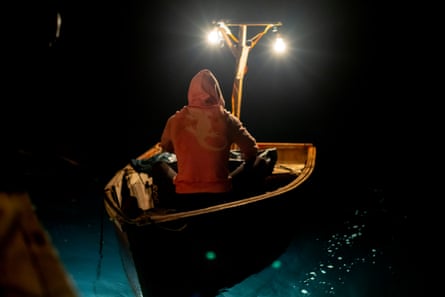 man in a small rowing boat at night