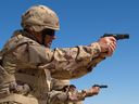 Members of the Military Police and the Area Security Force practice firing the Browning 9mm pistol from the kneeling position at the weapons range during Operation IMPACT on March 4, 2015.   Photo: OP Impact, DND 