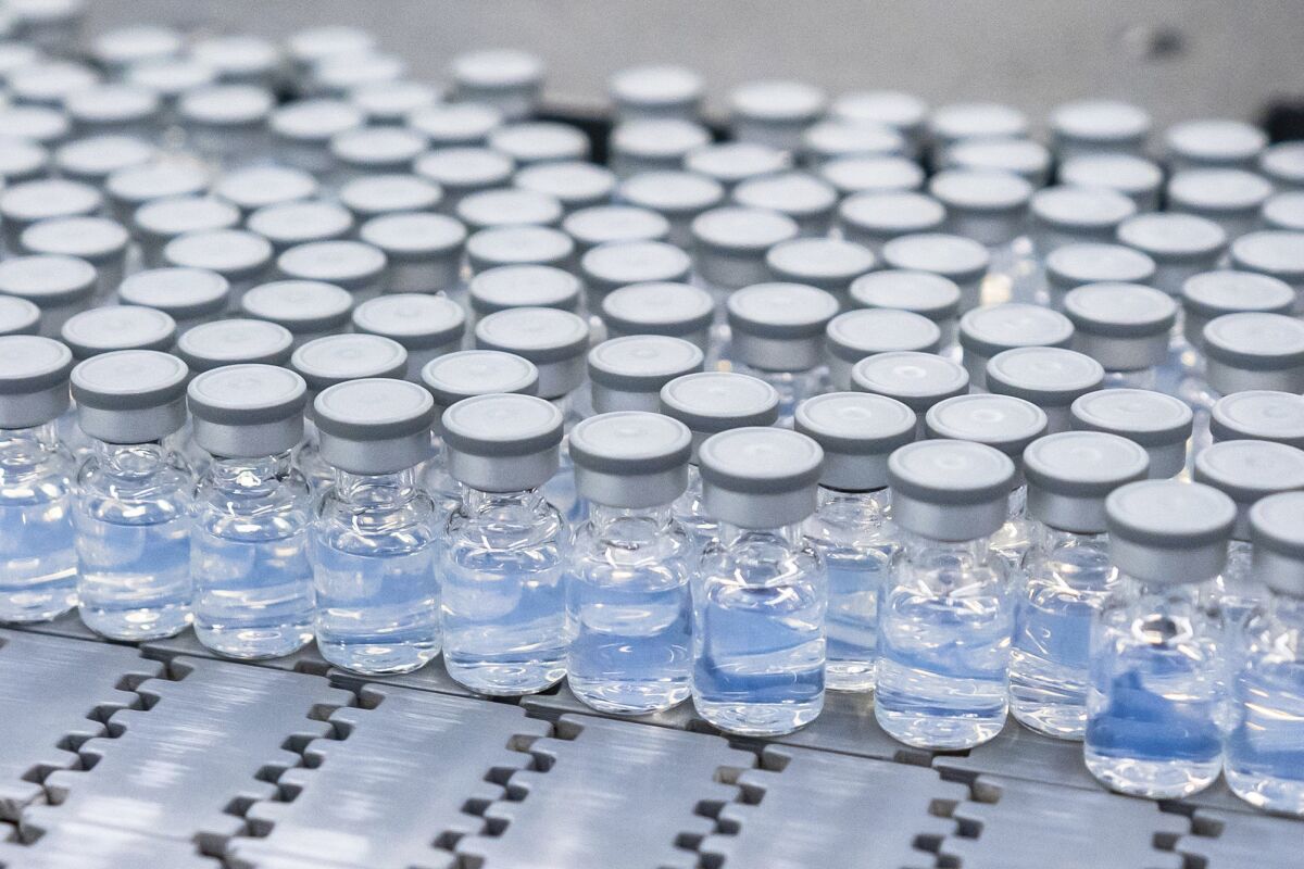 A close-up photo of a bunch of small clear vials holding a clear liquid.